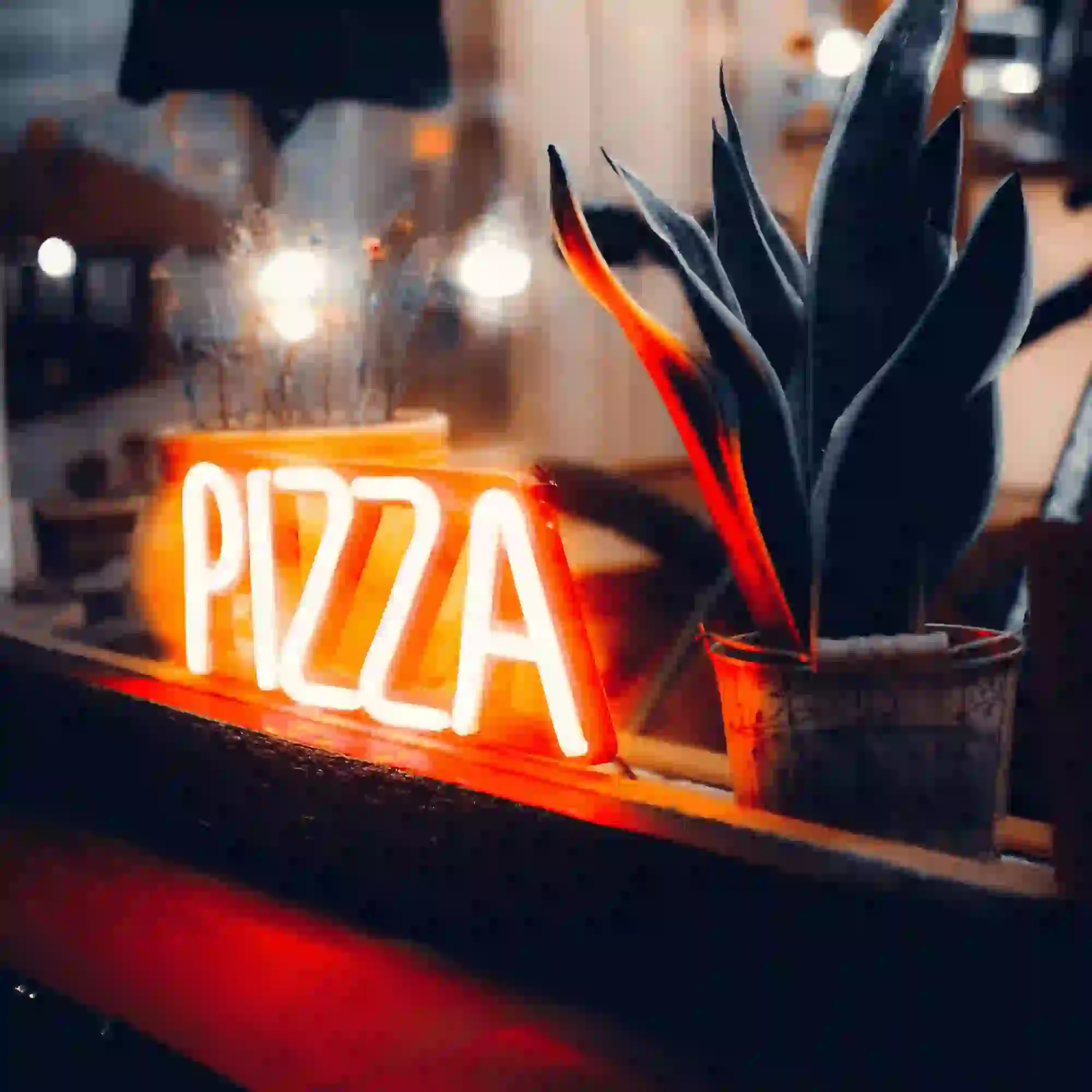 A neon red pizza sign in the window.